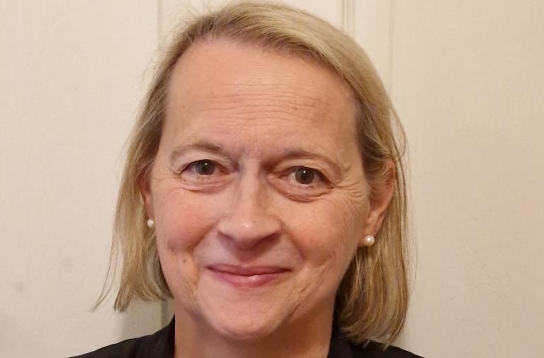 Headshot of Jennifer Riches-Bishop who has bobbed blonde hair and brown eyes and is wearing a black cardigan