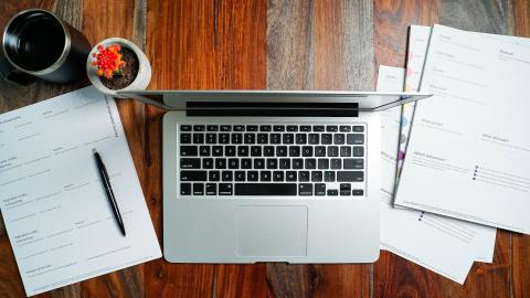 A laptop and some papers on a desk