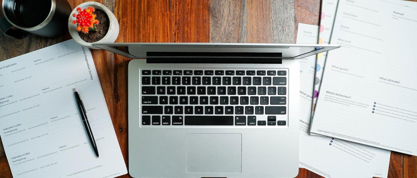 A laptop and some papers on a desk